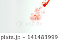 Abstract close-up of blood dissolving and dispersing in water, creating dynamic red swirls and fluid patterns, isolated on a white background, slow motion 141483999