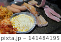 Sizzling Korean BBQ Pork Belly (Samgyeopsal) Grilling with Kimchi and Garlic on a Hot Plate 141484195