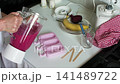 In the kitchen, someone blends strawberries, bananas, and beets to make ice cream. The mixture is then poured into molds. Simple steps create a tasty treat 141489722