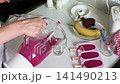 In a home kitchen, a person prepares homemade ice cream using fresh strawberries, ripe bananas, and beets. The mixture is blended and poured into molds for freezing 141490213