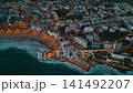 illuminated streets of Spanish touristic city Salou, Catalonia, aerial view of beach, sea and coast with palm trees, aerial drone view 4k 141492207