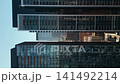 modern tall skyscraper building, glass and metal exterior with mirrors and reflections, urban office or residential tower 4k 141492214