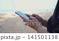 Woman using smartphone on tropical beach, mobile communication and travel lifestyle 141501138