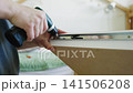 Assembling furniture with screwdriver, focusing on detailed action progression 141506208