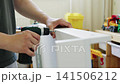 Person assembling furniture with screwdriver in a child's room 141506212