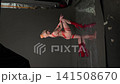 Woman in Red Tape Costume Posing in Studio 141508670