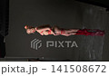 Woman in Red Tape Costume Posing in Studio 141508672