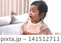 A little girl eating baby food while crying. A little girl eating baby food while crying. 141512711