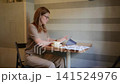 Woman using tablet with floor plans in cafe workspace 141524976