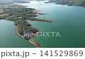Aerial panorama of Lake Plastiras showing green peninsula with road surrounded by calm turquoise water and mountain range in Thessaly Greece for travel background. High quality 4k footage 141529869