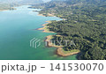 Aerial high altitude video of Lake Plastiras shoreline with green pine forest and distant mountain villages in Karditsa Greece for travel and ecosystem concept. High quality 4k footage 141530070