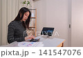 一位女士正在瀏覽股票價格網站，考慮投資事宜。 141547076