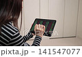 鏡頭拉近一位女士的雙手，她正在用平板電腦查看股票價格。 141547077