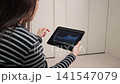 特寫鏡頭拍攝一位女士在網站上查看股票價格走勢時的雙手。 141547079