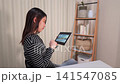 一位女士正在用平板電腦瀏覽財經網站。 141547085