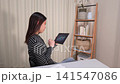 一位女士正在用平板電腦查看股票價格。 141547086