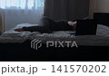 Depressed Woman Closing Laptop on Bed Side View 141570202