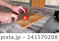 Slicing Red Tomato on Cutting Board 141570208