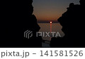 夕陽西下，緩緩沉入宇都呂海岸線上形狀奇特的岩石之間。 141581526