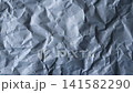 Static close-up video of wrinkled blue-gray wrapping paper with subtle horizontal stripes and pronounced fibers. A distressed grunge background for vintage, editorial and creative design projects. 141582290