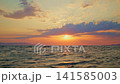Golden Sunset Over Wavy Sea and Distant Mountains 141585003