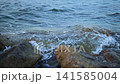 Ocean Waves Gently Crashing Against Coastal Rocks 141585004
