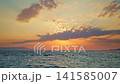 Golden Sunset Over Ocean Horizon With Distant Mountains 141585007