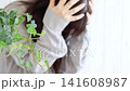 A woman holding her head in her hands, looking troubled; suffering alone. 141608987