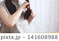 Brushing shoulder-length hair 141608988