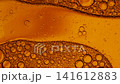 Orange liquid with bubbles of various sizes slowly floating and merging in a macro shot 141612883