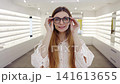 Bright showroom with confident female optician. Chic retail space showcasing confident female optician among fashionable eyewear displays with warm 141613655