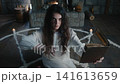 Woman standing inside pentagram circle reciting a spell, stone chamber illuminated by candles. Barefoot in long white dress, solemn posture, invocation exorcism atmosphere 141613659