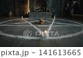 A skull on chalk exorcism pentagram ritual circle. Candle flames on stone floor 141613665