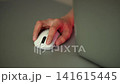 Professional gamer, streamer clicking and scrolling with wireless gaming mouse on gray mat, with colorful rgb lights concept of from computer screen onto player hand and desk, close-up, slow motion. 141615445