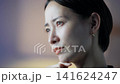 A middle-aged woman contemplates in a dark room. Dissatisfaction, anxiety, doubts, worries, business, stress, troubles, problems, serious, management. 141624247
