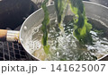 Blanched wakame seaweed, scooped up with chopsticks - a Japanese cooking technique. 141625007