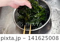 Cooling wakame seaweed after blanching it in hot water is a Japanese cooking preparation method. 141625008