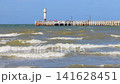 Sea Waves with Distant Lighthouse and Pier, Relaxing Seascape on a Sunny Day, Nautical Horizon View. Nieuwpoort town in Belgium, Europe. Slow motion footage. 141628451
