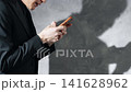 A man using a smartphone and his silhouette. (Keywords: worry, trouble, problem, anxiety, distress, question, serious, crime) 141628962