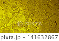 Yellow oil bubbles of different sizes floating and mixing slowly in a liquid forming an emulsion 141632867