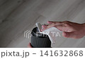 Macro shot of hands carefully wiping dust off a modern camera lens element with white cloth 141632868