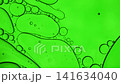 Green oil bubbles mixing with water, forming abstract texture and patterns 141634040