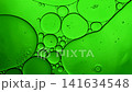 Green oil bubbles mixing with water, forming abstract texture and patterns 141634548