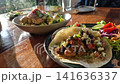 Taco and chicken spaghetti American diner's style food on wood table and sun light 141636337