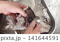 A chef's hands as he removes the scales from the bones of a sea bream with a spoon / Scaling sea bream bones simmered 141644591
