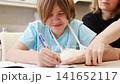 Girl learns to write with injured hand in home setting 141652117