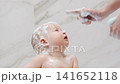 Child enjoys bath time with soap and water in home bathroom 141652118