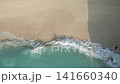 Top-down aerial shot of a wave hitting the shore 141660340
