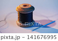 Black thread with needle on white table 141676995