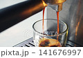 Brewing espresso with two streams pouring into glass cup 141676997
